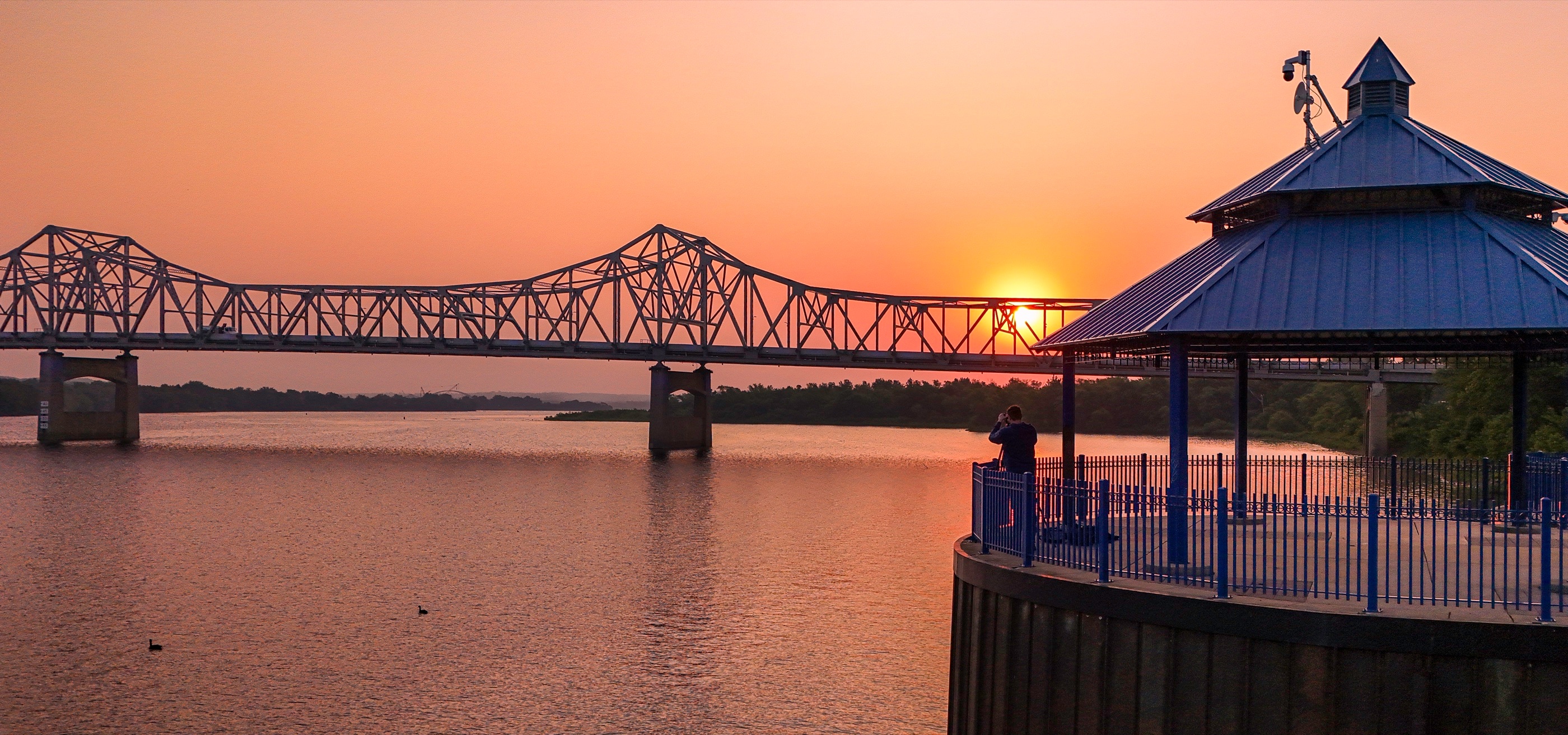Aerial riverfront view with bridge at sunset